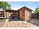 A covered patio with a fire pit sits next to brick exterior and brick patio in the backyard at 1560 Pueblo Ct, Thornton, CO 80229