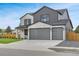 Beautiful two-story home showcasing modern curb appeal with gray siding, stone accents, three-car garage, and landscaping at 3343 S Newcombe St, Lakewood, CO 80227