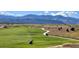 Scenic view of a lush golf course with meandering fairways, mountain backdrop, and golf carts on the path at 3343 S Newcombe St, Lakewood, CO 80227