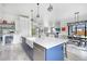 Open concept kitchen has a large island, bar fridge, and modern fixtures at 3343 S Newcombe St, Lakewood, CO 80227