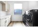 Bright laundry room features modern washer and dryer, sleek cabinets and countertops, and a window at 3343 S Newcombe St, Lakewood, CO 80227