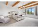 Serene main bedroom featuring exposed wood beams, large windows, and stylish furnishings at 3343 S Newcombe St, Lakewood, CO 80227
