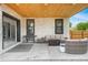 Inviting outdoor patio features stone accents, a grill, a seating area with a fire pit, and a wood ceiling at 3343 S Newcombe St, Lakewood, CO 80227
