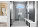 Modern shower with gray tiling, glass door, a bench seat, and a view to the vanity at 3343 S Newcombe St, Lakewood, CO 80227