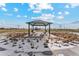 Park gazebo with picnic tables surrounded by a beautiful open grassy area with snow and vegetation at 2165 Alyssa St, Fort Lupton, CO 80621
