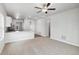 Open-concept living area with plush carpeting and a view of the modern kitchen at 2165 Alyssa St, Fort Lupton, CO 80621