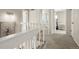 Well-lit hallway with carpeted stairs leading to the upper level, showcasing an open floor plan at 6988 S Knolls Way, Centennial, CO 80122