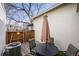 Private fenced patio with table, chairs, and shade for outdoor relaxation and entertaining at 6988 S Knolls Way, Centennial, CO 80122