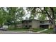 Two-story tan apartment building featuring a grassy lawn, bench and several large leafy trees at 755 S Clinton St # 1B, Denver, CO 80247