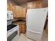 Kitchen featuring light wood cabinets and speckled countertops, with a range, microwave and a refrigerator at 755 S Clinton St # 1B, Denver, CO 80247