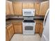 Kitchen showcasing light wood cabinets, speckled countertops, and modern appliances like a range and microwave at 755 S Clinton St # 1B, Denver, CO 80247