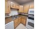 Kitchen boasting light wood cabinets and speckled countertops, equipped with essential appliances at 755 S Clinton St # 1B, Denver, CO 80247