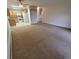 Living room view showcases neutral carpeting and the adjacent kitchen with wood cabinets and white appliances at 755 S Clinton St # 1B, Denver, CO 80247