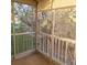 Cozy screened patio with decorative railings offers tranquil views of the surrounding greenery at 755 S Clinton St # 1B, Denver, CO 80247