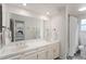 Bright bathroom with a double vanity, large mirror, and a shower with a decorative curtain at 10385 E Ida Ave, Greenwood Village, CO 80111