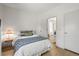 Cozy bedroom with white walls, wood floors, and a door leading to the laundry room at 10385 E Ida Ave, Greenwood Village, CO 80111