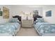 Shared bedroom with two twin beds, matching bedside lamps and neutral dresser at 10385 E Ida Ave, Greenwood Village, CO 80111