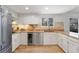 Well-lit kitchen with stainless steel appliances, light cabinetry, and a window overlooking the yard at 10385 E Ida Ave, Greenwood Village, CO 80111