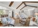 Open-concept living room with vaulted ceilings, exposed beams, and seamless flow to the dining area at 10385 E Ida Ave, Greenwood Village, CO 80111