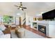 Open living room featuring a fireplace, built-in shelving, hardwood floors, and plenty of natural light at 13504 Pecos St, Westminster, CO 80234