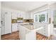 Well-lit kitchen featuring white cabinets, an island, and modern appliances, offering a clean and functional space at 19 Benthaven Pl, Boulder, CO 80305