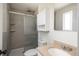 Bathroom featuring modern shower with gray tiling and frosted glass door, along with a granite-look vanity at 8170 S Marshall Ct, Littleton, CO 80128