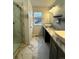 Bathroom with modern vanity, marble counter top, tile floors, and tiled walk-in shower at 9377 Longstone Dr, Parker, CO 80134