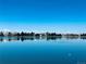 Calm lake reflecting the sky with lakeside homes in the background, showcasing a peaceful neighborhood setting at 9377 Longstone Dr, Parker, CO 80134