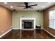 Living room showcasing a cozy fireplace, hardwood floors, and a ceiling fan at 9377 Longstone Dr, Parker, CO 80134