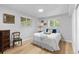 Bright bedroom features hardwood floors, a queen bed, and dual windows for lots of natural light at 8333 Depew Way, Arvada, CO 80003