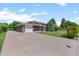 An exterior view of a brick home with a long driveway and well maintained lawn at 8333 Depew Way, Arvada, CO 80003