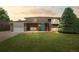 Charming brick home featuring a well-maintained front lawn and a bright blue front door at 8333 Depew Way, Arvada, CO 80003