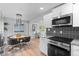 Modern kitchen view into the living room. Granite counters, black backsplash, and stainless appliances at 8333 Depew Way, Arvada, CO 80003