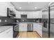 Modern kitchen featuring stainless steel appliances, white cabinetry, and granite countertops at 8333 Depew Way, Arvada, CO 80003