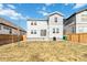 View of the backyard, showing the lawn, landscaping, and the exterior of a two-story home with gray siding at 27798 E 7Th Pl, Aurora, CO 80018