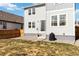 Exterior view of the backyard, showcasing a lawn, landscaping, and the side of the two-story home with gray siding at 27798 E 7Th Pl, Aurora, CO 80018