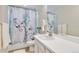 This bathroom has a modern floral shower curtain, white tile, and a large mirror over the sink at 27798 E 7Th Pl, Aurora, CO 80018
