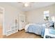This bedroom has a ceiling fan, hardwood floors, a white dresser with mirror and is well-lit from the window at 27798 E 7Th Pl, Aurora, CO 80018
