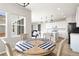 Cozy dining area featuring a round wooden table, comfortable chairs, and views of the modern kitchen at 27798 E 7Th Pl, Aurora, CO 80018