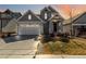 Inviting two-story home featuring an attached two-car garage and a cozy porch with decorative lighting at 27798 E 7Th Pl, Aurora, CO 80018