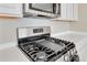 Close up of stainless steel gas range and microwave, integrated perfectly in the kitchen design at 27798 E 7Th Pl, Aurora, CO 80018