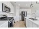 Well-equipped kitchen with stainless steel appliances and sleek white cabinetry at 27798 E 7Th Pl, Aurora, CO 80018