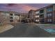 Exterior shot of the condo complex showcasing its brick facade, balconies, and well-maintained landscaping at 2896 W Riverwalk Cir # A214, Littleton, CO 80123