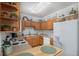 Cozy kitchen featuring wooden cabinets and white appliances for a warm, inviting cooking space at 2896 W Riverwalk Cir # A214, Littleton, CO 80123