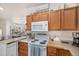 Bright kitchen with wooden cabinets, white appliances, and open design seamlessly connects to the dining area at 2896 W Riverwalk Cir # A214, Littleton, CO 80123