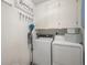 Bright laundry room with white cabinets, a hanging rack, and washer and dryer units at 2896 W Riverwalk Cir # A214, Littleton, CO 80123