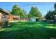 Spacious backyard with lush green grass, mature trees, shed, and covered patio, great for outdoor living at 2814 S Winona Ct, Denver, CO 80236
