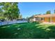 Large, flat backyard with a full privacy fence, lush grass, and a covered patio perfect for relaxation at 2814 S Winona Ct, Denver, CO 80236