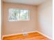 A bedroom with hardwood floors, a window with natural light, and neutral paint colors at 1170 Kingston St, Aurora, CO 80010