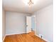 Bright bedroom featuring hardwood floors, fresh paint, and a doorway to another room at 1170 Kingston St, Aurora, CO 80010